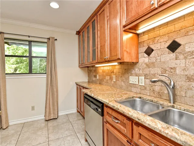a kitchen with stainless steel appliances granite countertop a sink and a window