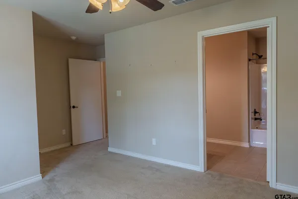 an empty room with closet and a chandelier fan