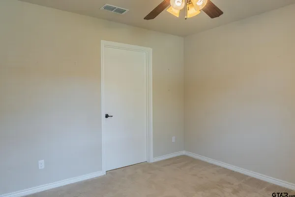 an empty room with a chandelier fan