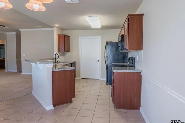a room with kitchen island cabinets and refrigerator