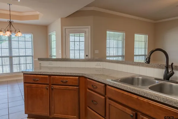 a kitchen with granite countertop a sink and wooden cabinets