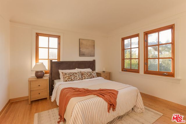 a bedroom with a bed and two windows