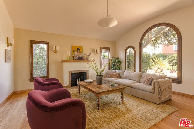 a living room with furniture a fireplace and a large window