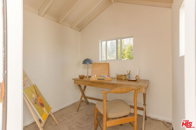 a view of a workspace with furniture and window