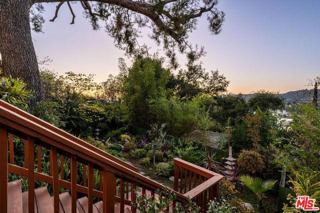 a view of balcony with wooden floor and trees in the back