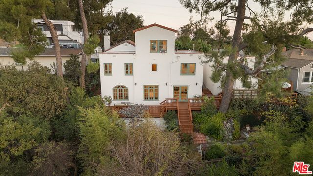 a view of a white house with a white fence next to a house