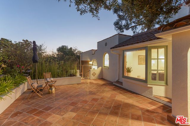 a view of a chair and table in backyard of a house