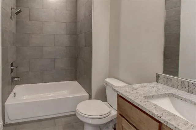 a bathroom with a granite countertop toilet a sink and bathtub
