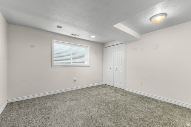 1822 East 9800th Street South Sandy, UT 84092 - Photo 20 of 38 Unfurnished bedroom featuring carpet floors, a textured ceiling, and a closet