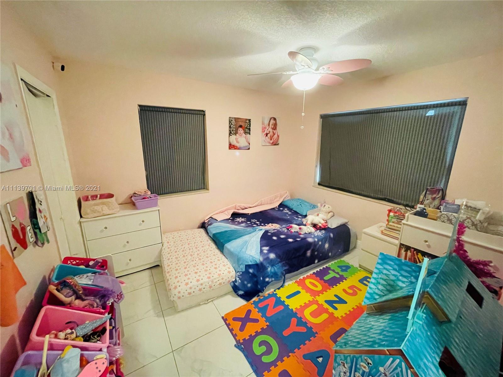 211 Southeast 3rd Street Dania Beach, FL 33004 - Photo 16 of 21 a bedroom with a bed and a flat screen tv