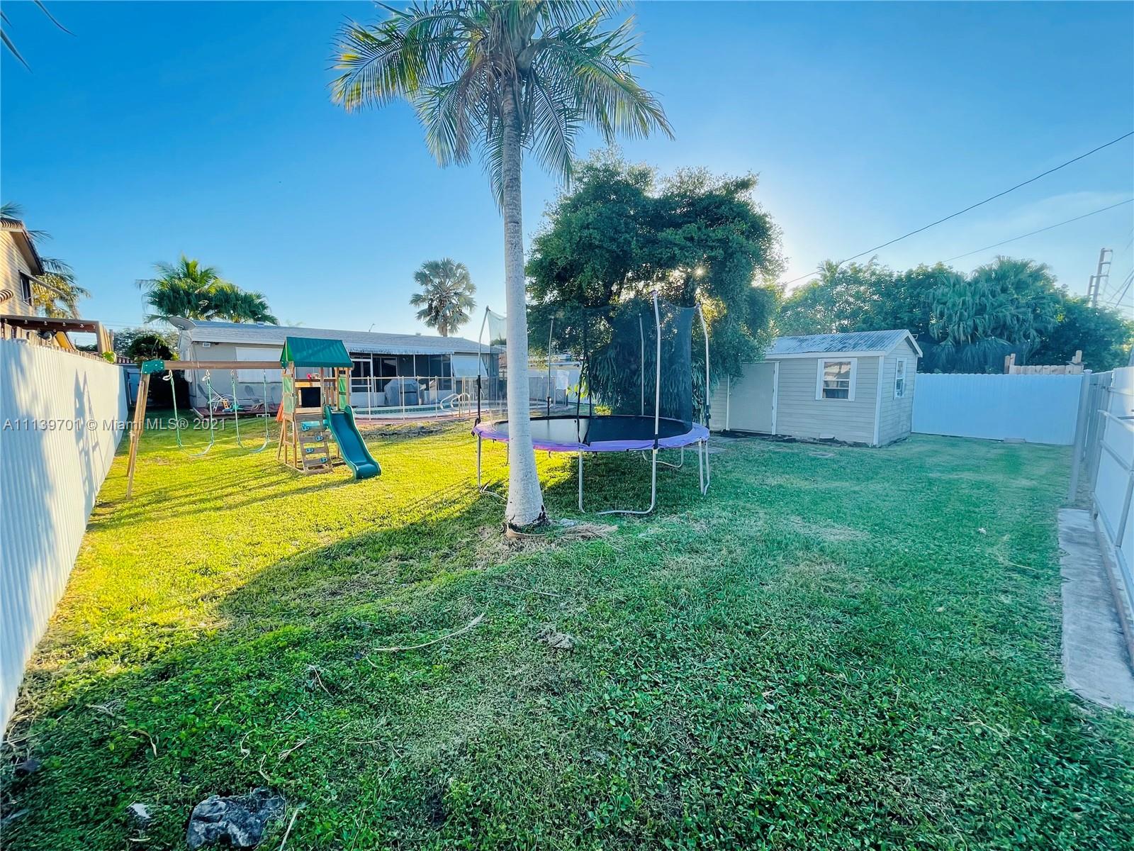 211 Southeast 3rd Street Dania Beach, FL 33004 - Photo 20 of 21 a view of a swimming pool with a table and palm trees
