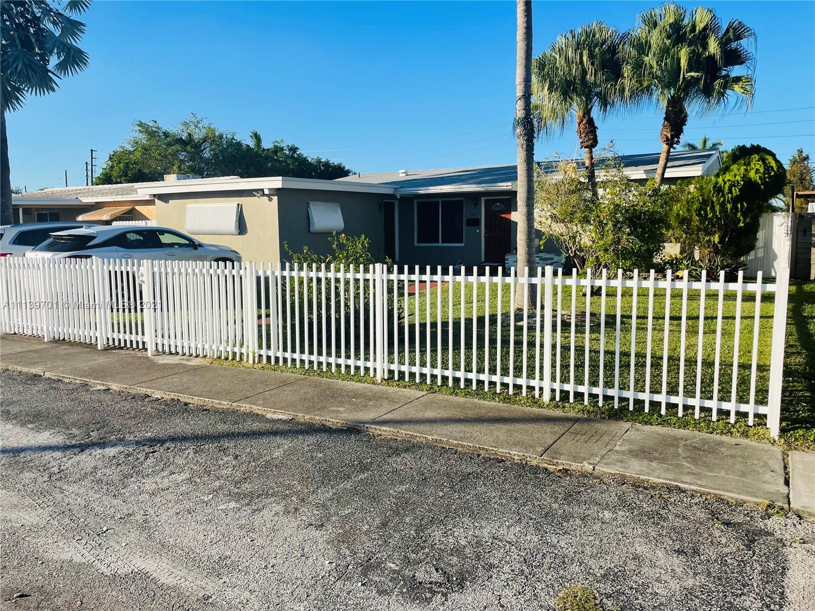 211 Southeast 3rd Street Dania Beach, FL 33004 - Photo 3 of 21 a front view of a house with a garden