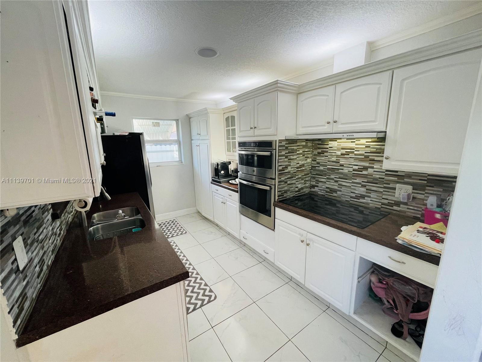 211 Southeast 3rd Street Dania Beach, FL 33004 - Photo 8 of 21 a kitchen with stainless steel appliances kitchen island granite countertop a stove and a sink