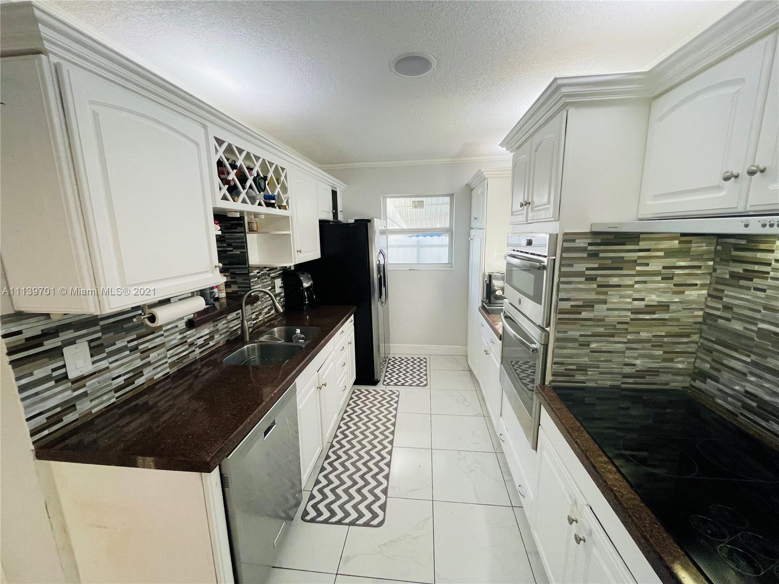 211 Southeast 3rd Street Dania Beach, FL 33004 - Photo 9 of 21 a kitchen with a refrigerator and a stove