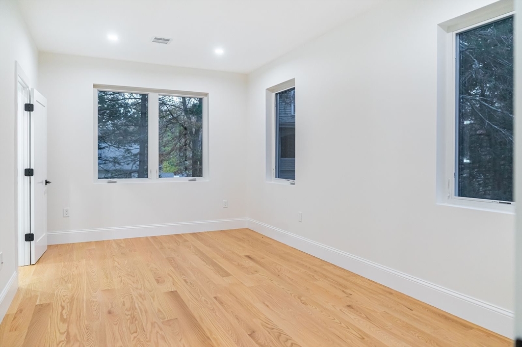 98 Hunnewell Street Needham, MA 02494 - Photo 25 of 36 an empty room with wooden floor and windows