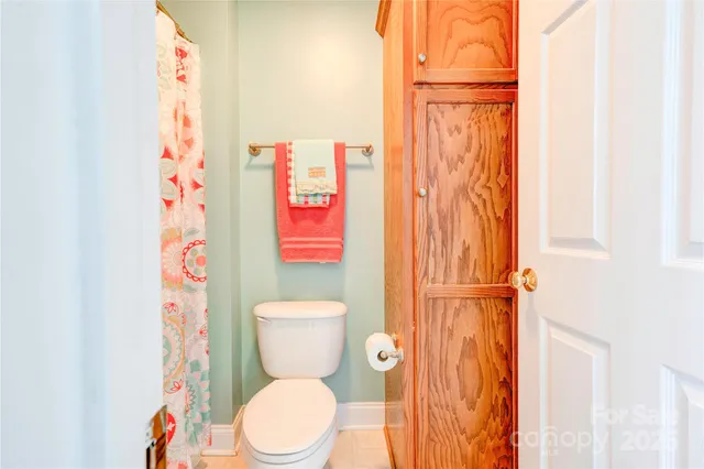 a white toilet sitting next to a shower curtain