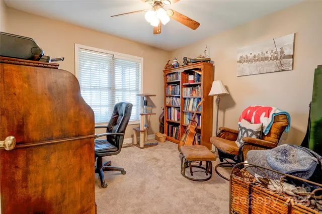 a view of a workspace with furniture and a window