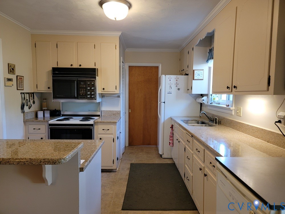 8241 Virginia Avenue West Point, VA 23181 - Photo 4 of 18 a kitchen with stainless steel appliances a stove a sink a refrigerator and a microwave