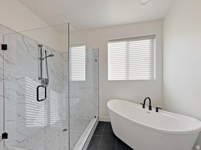 851 Grandview Drive Morgan, UT 84050 - Photo 22 of 68 Freestanding soaking tub with matte black fixtures, alongside a glass-enclosed shower featuring large format veined wall tiles and a rainfall showerhead