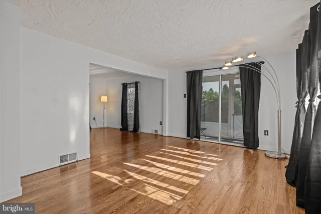 a view of a room with wooden floor and a tub