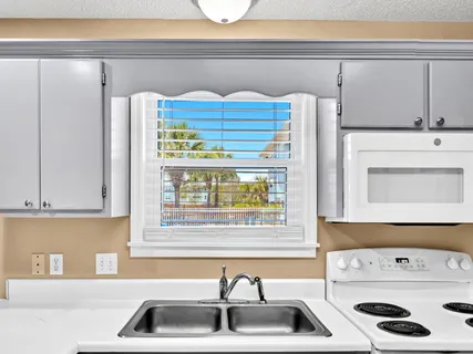 a kitchen with a sink a stove and a refrigerator