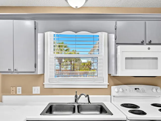 a kitchen with a sink a stove and a refrigerator