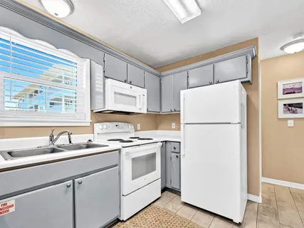 a kitchen with a refrigerator sink stove and cabinets