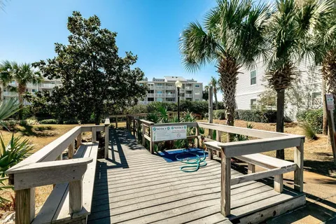 a view of a roof deck with table and chairs a barbeque with potted plants and large trees