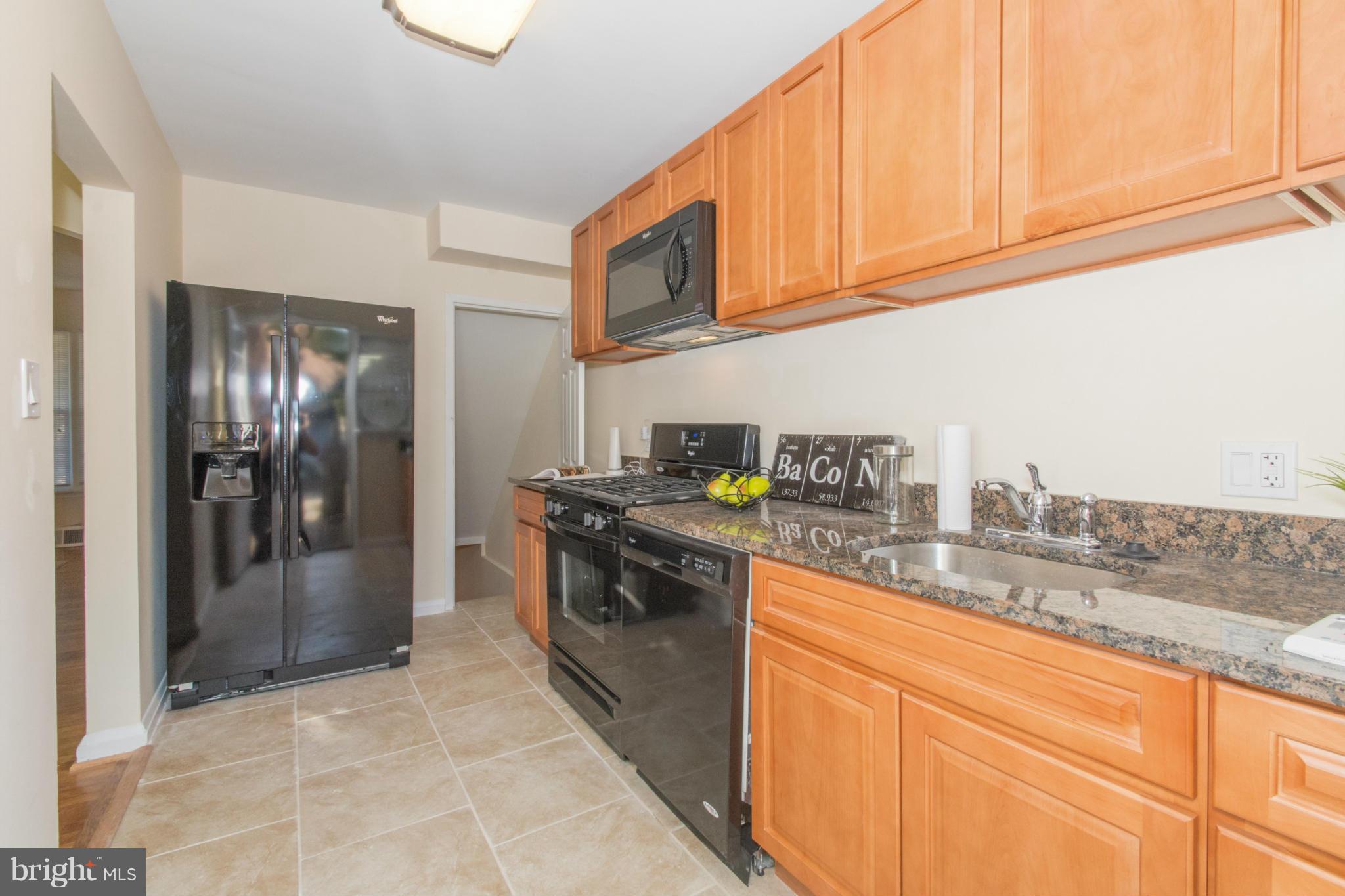604 Brisbane Road Baltimore, MD 21229 - Photo 12 of 30 a kitchen with stainless steel appliances granite countertop a stove a sink and a refrigerator