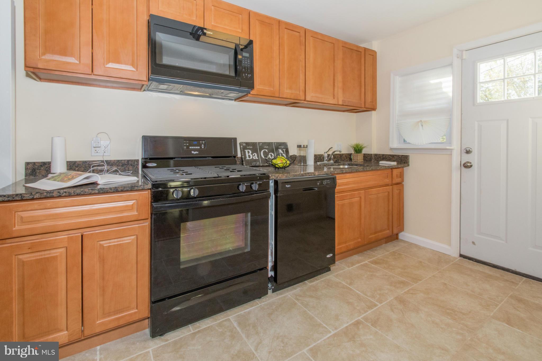 604 Brisbane Road Baltimore, MD 21229 - Photo 9 of 30 a kitchen with stainless steel appliances granite countertop a stove a sink and a microwave