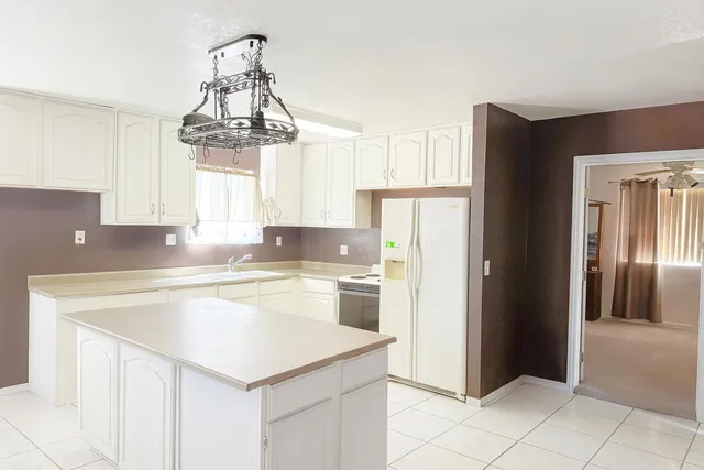 a view of an empty room with a chandelier fan