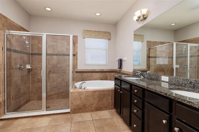 a bathroom with a granite countertop sink a toilet a mirror and shower