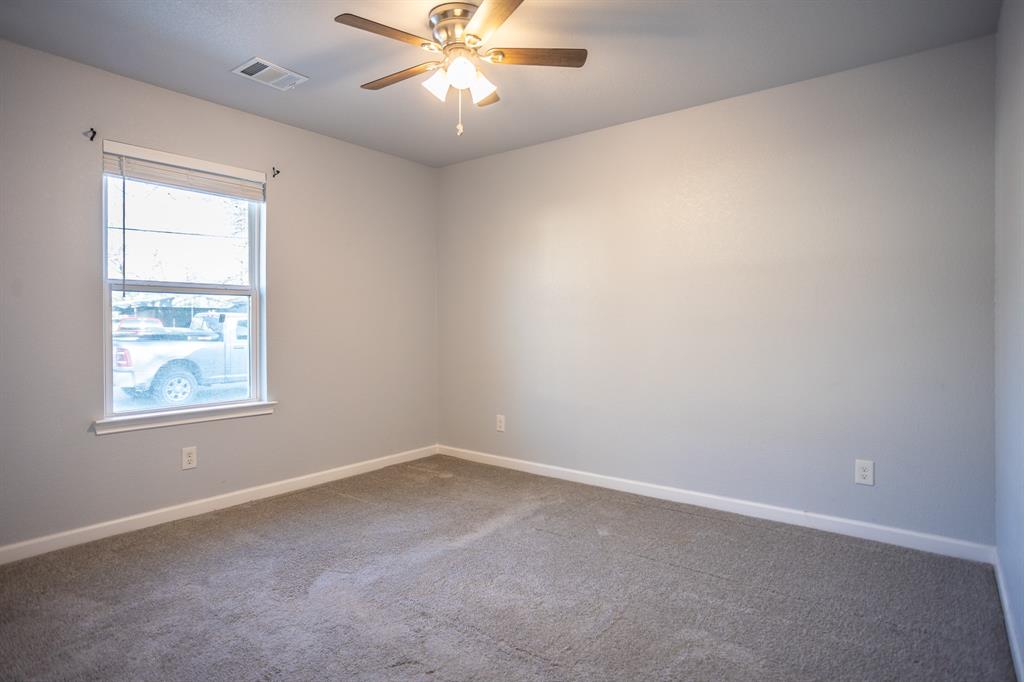 815 Ritchey Street Gainesville, TX 76240 - Photo 14 of 18 an empty room with a window and a fan