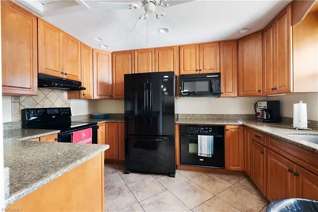 a kitchen with stainless steel appliances granite countertop a refrigerator stove and sink