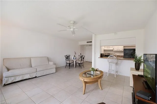 a living room with furniture and kitchen view