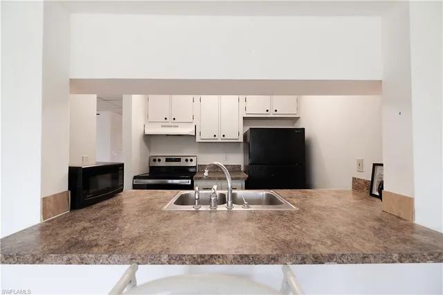 a kitchen with stainless steel appliances kitchen island granite countertop a sink and cabinets