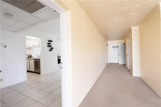 a view of a kitchen with white cabinets and a refrigerator