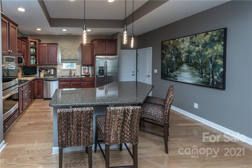4825 Polo Gate Boulevard Charlotte, NC 28216 - Photo 3 of 30 a view of a dining room with furniture a kitchen and chandelier