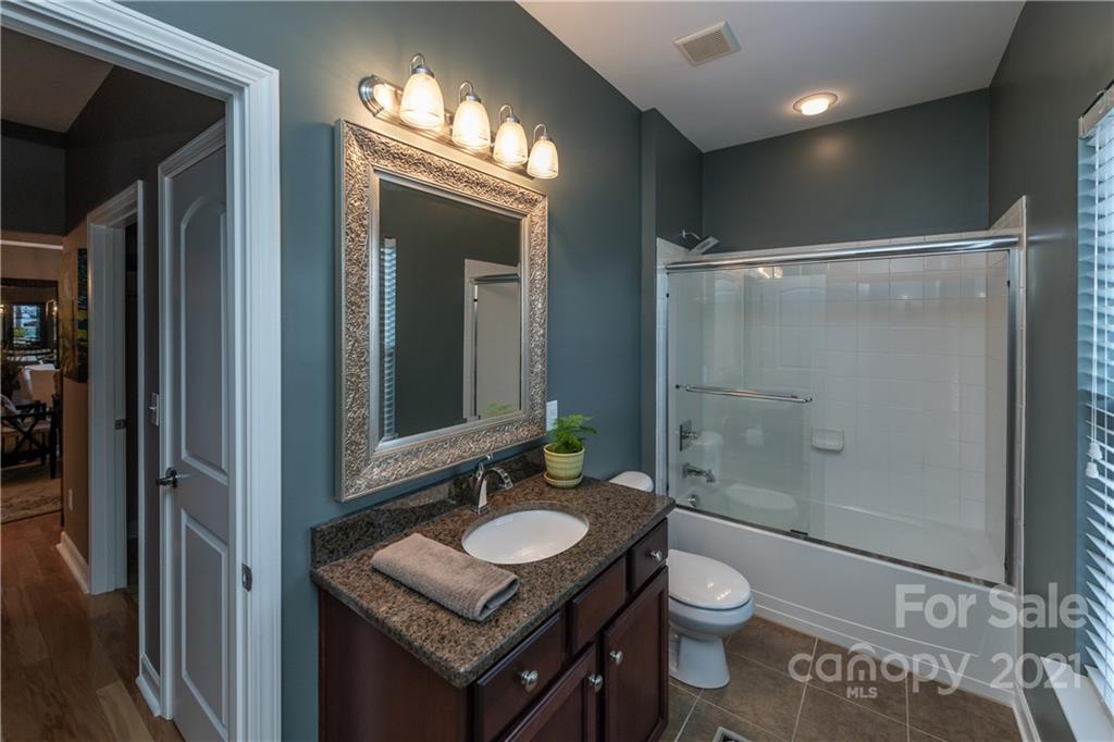 4825 Polo Gate Boulevard Charlotte, NC 28216 - Photo 23 of 30 a bathroom with a granite countertop sink toilet a mirror and shower