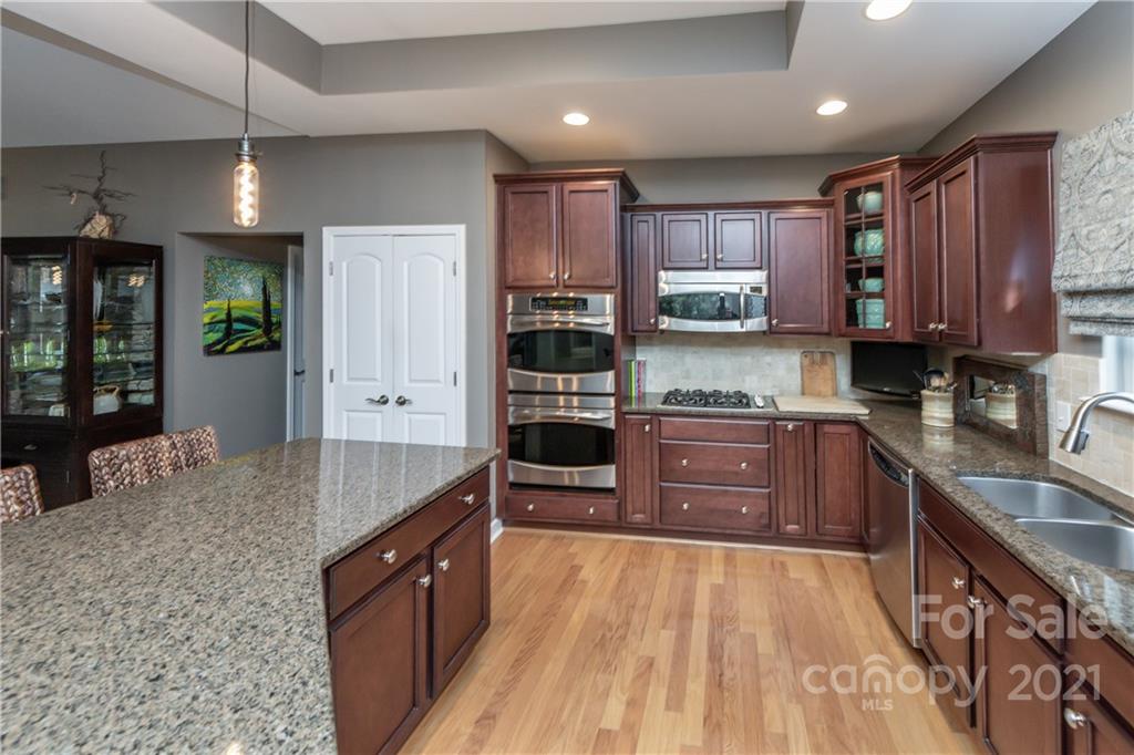4825 Polo Gate Boulevard Charlotte, NC 28216 - Photo 4 of 30 a kitchen with stainless steel appliances granite countertop a stove refrigerator and cabinets
