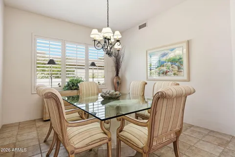 a dining room with furniture a large window and chandelier
