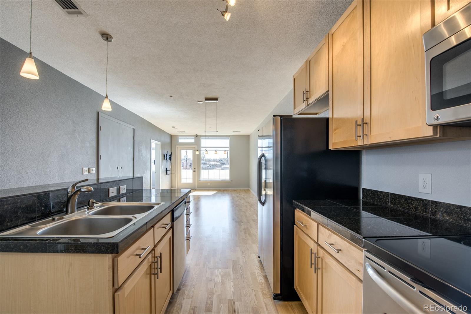 3101 Blake Street, Unit 308 Denver, CO 80205 - Photo 5 of 30 a kitchen that has a sink and a stove top oven