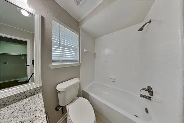 a white toilet sitting next to a bath tub