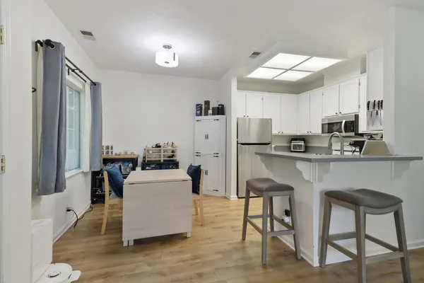 a living room with stainless steel appliances kitchen island granite countertop furniture and a refrigerator