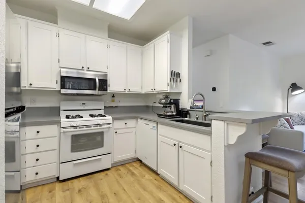 a kitchen with cabinets stainless steel appliances and a sink