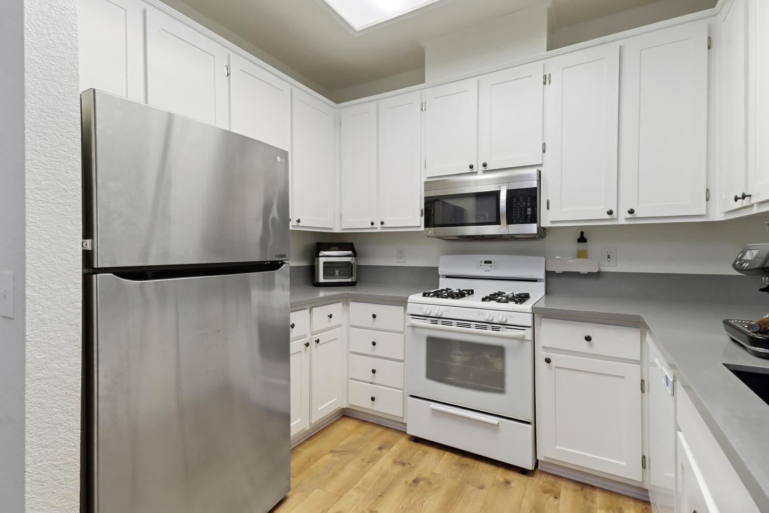 1175 Greene Terrace Davis, CA 95618 - Photo 19 of 35 a kitchen with stainless steel appliances white cabinets and a refrigerator