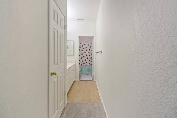 a view of a hallway with wooden floor and closet