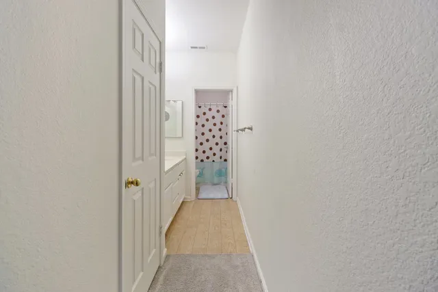 a view of a hallway with wooden floor and closet