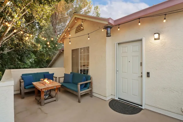 an outdoor view of a house with a table and chairs