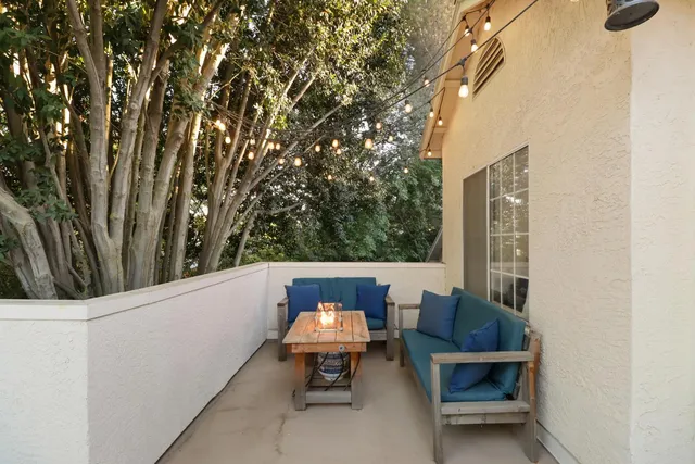 a view of a patio with table and chairs with wooden fence and plants